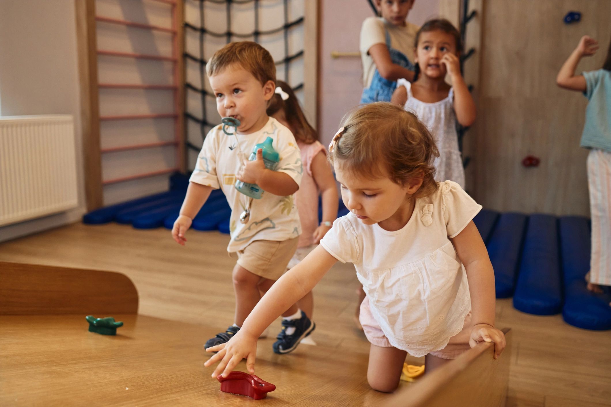Toddlers playing with toys in a bright indoor daycare playroom